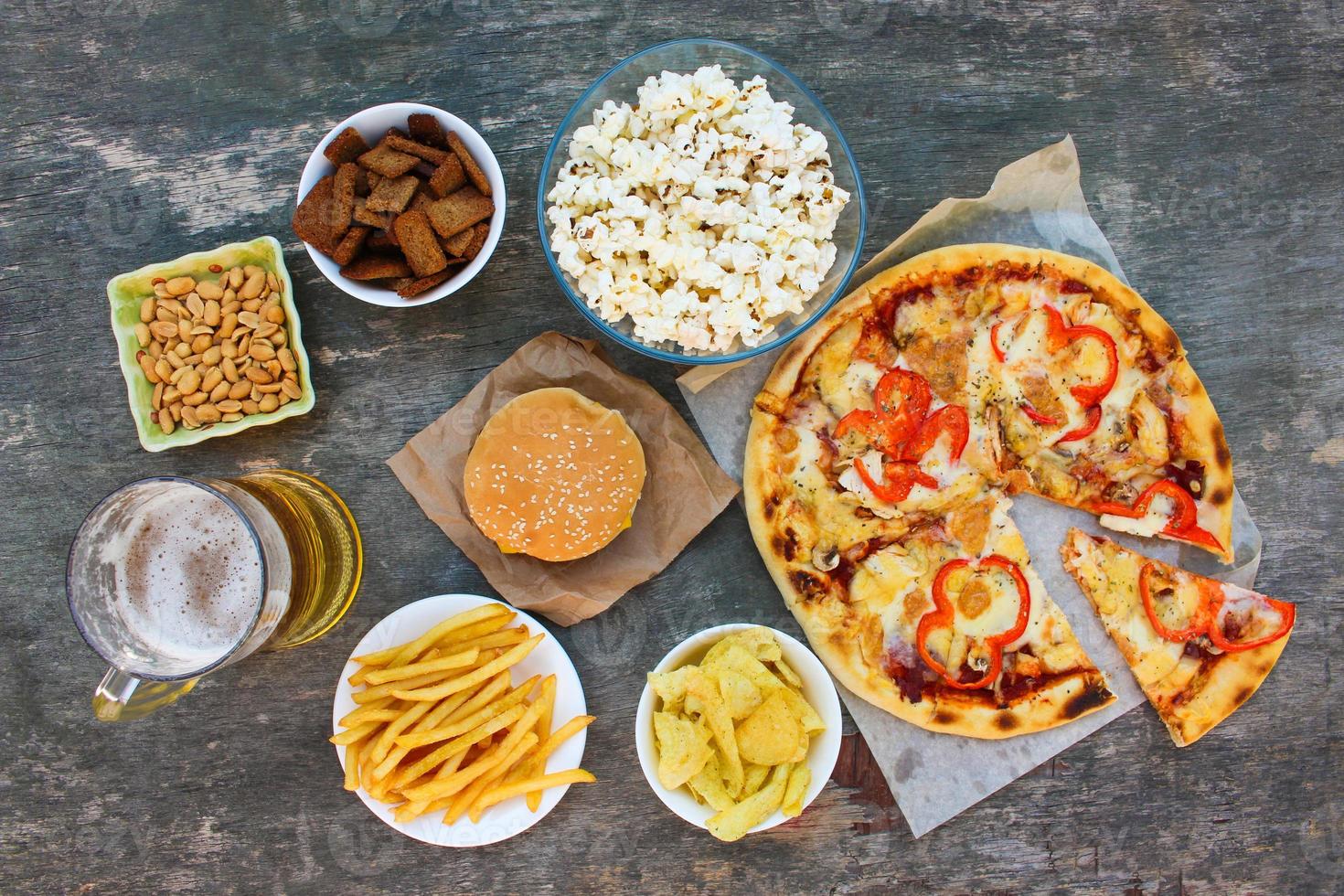Fast food on old wooden background. Concept of junk eating. Top view. photo