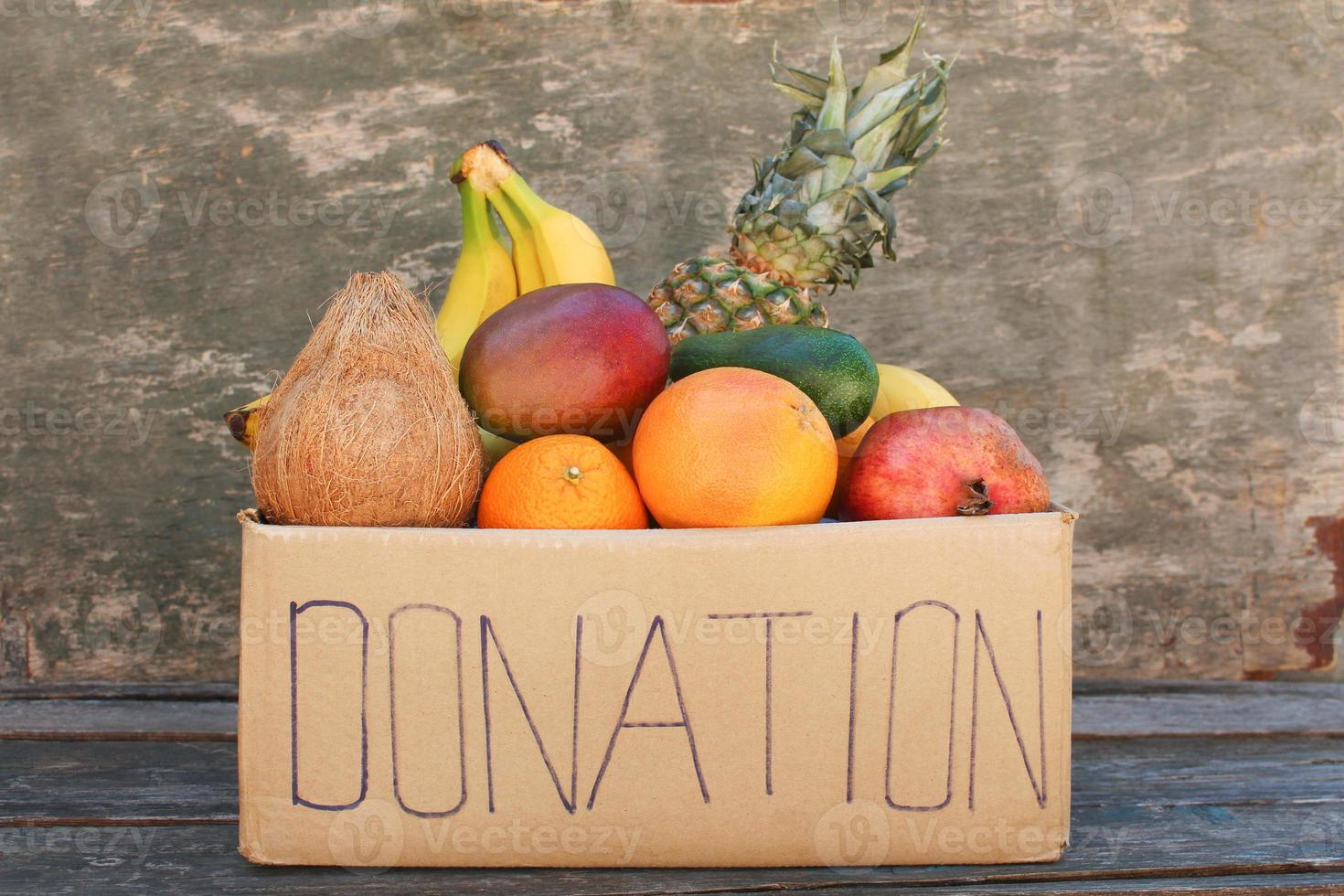 Donation box with food on old wooden background. photo