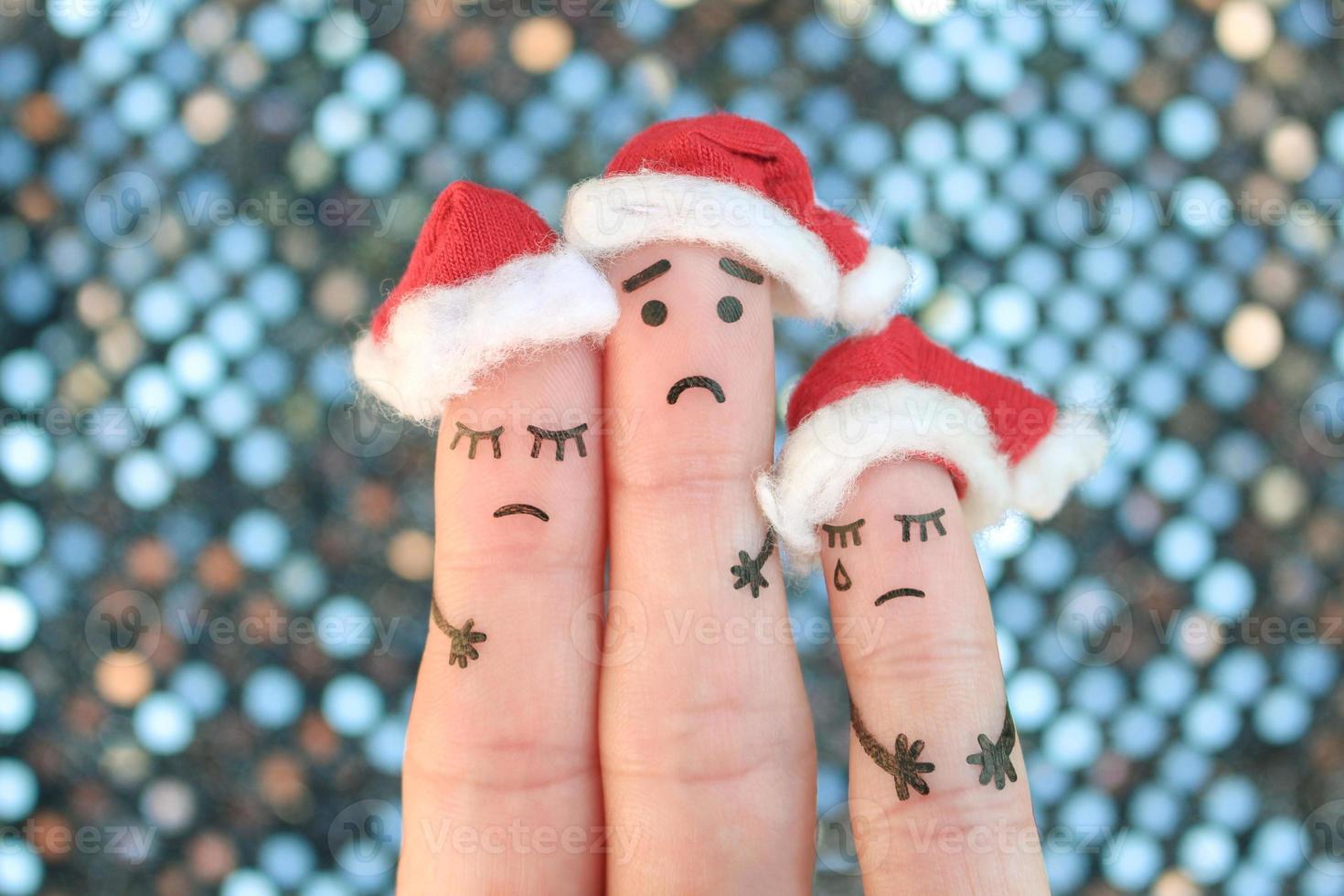 Fingers art of displeased family celebrates Christmas. Concept of group of sad people in new year hats. photo