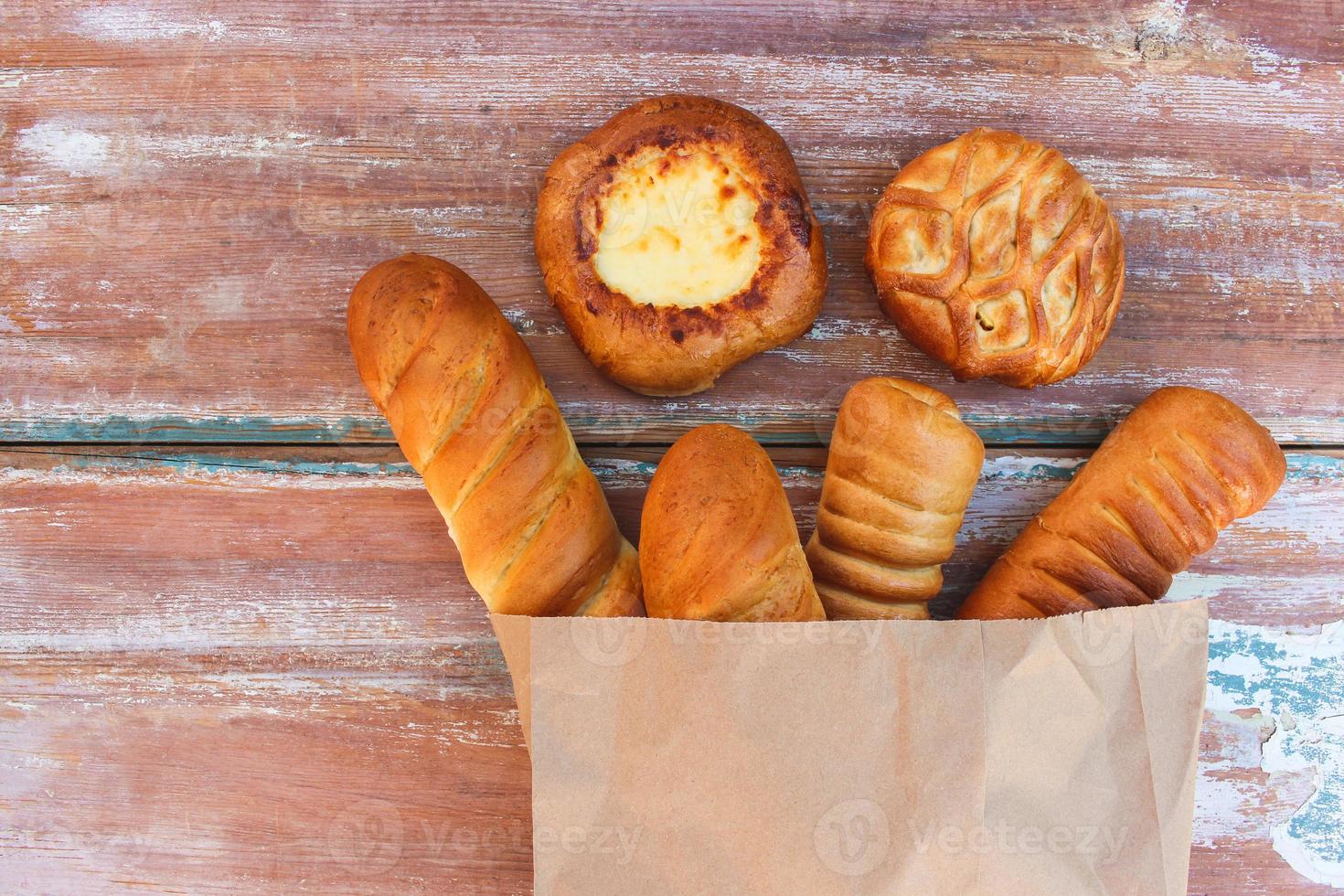 Bakery products in paper bag on table. Top view. photo
