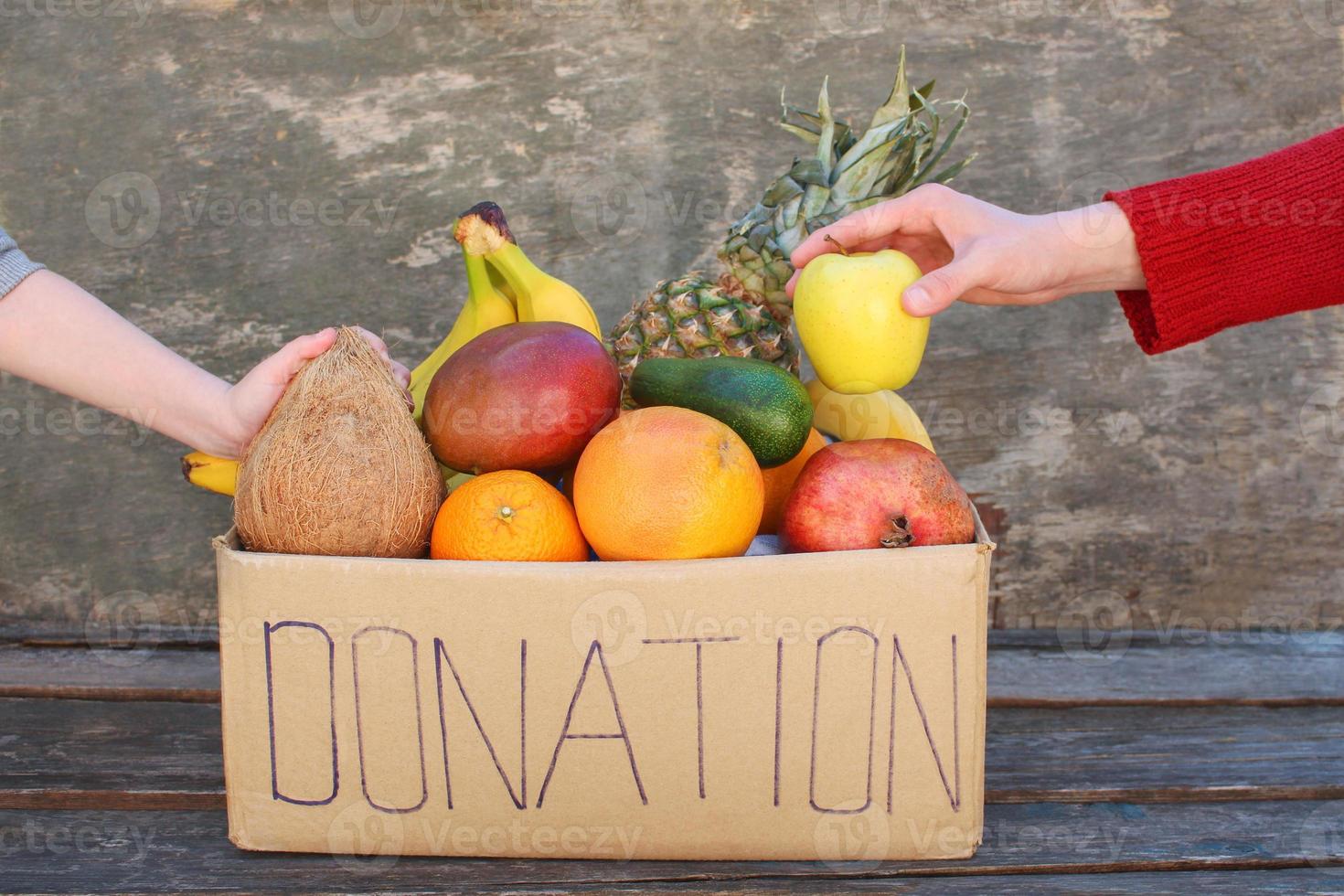 Donation box with food on old wooden background. photo