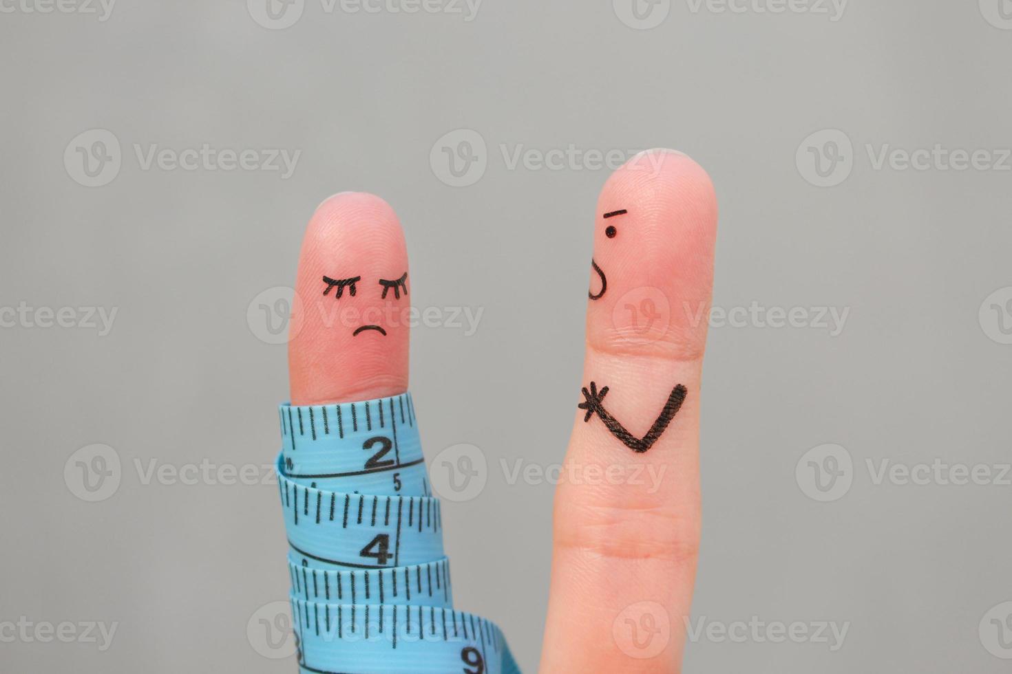 Fingers art of couple with meter. Concept husband is angry that his wife can not lose weight. photo