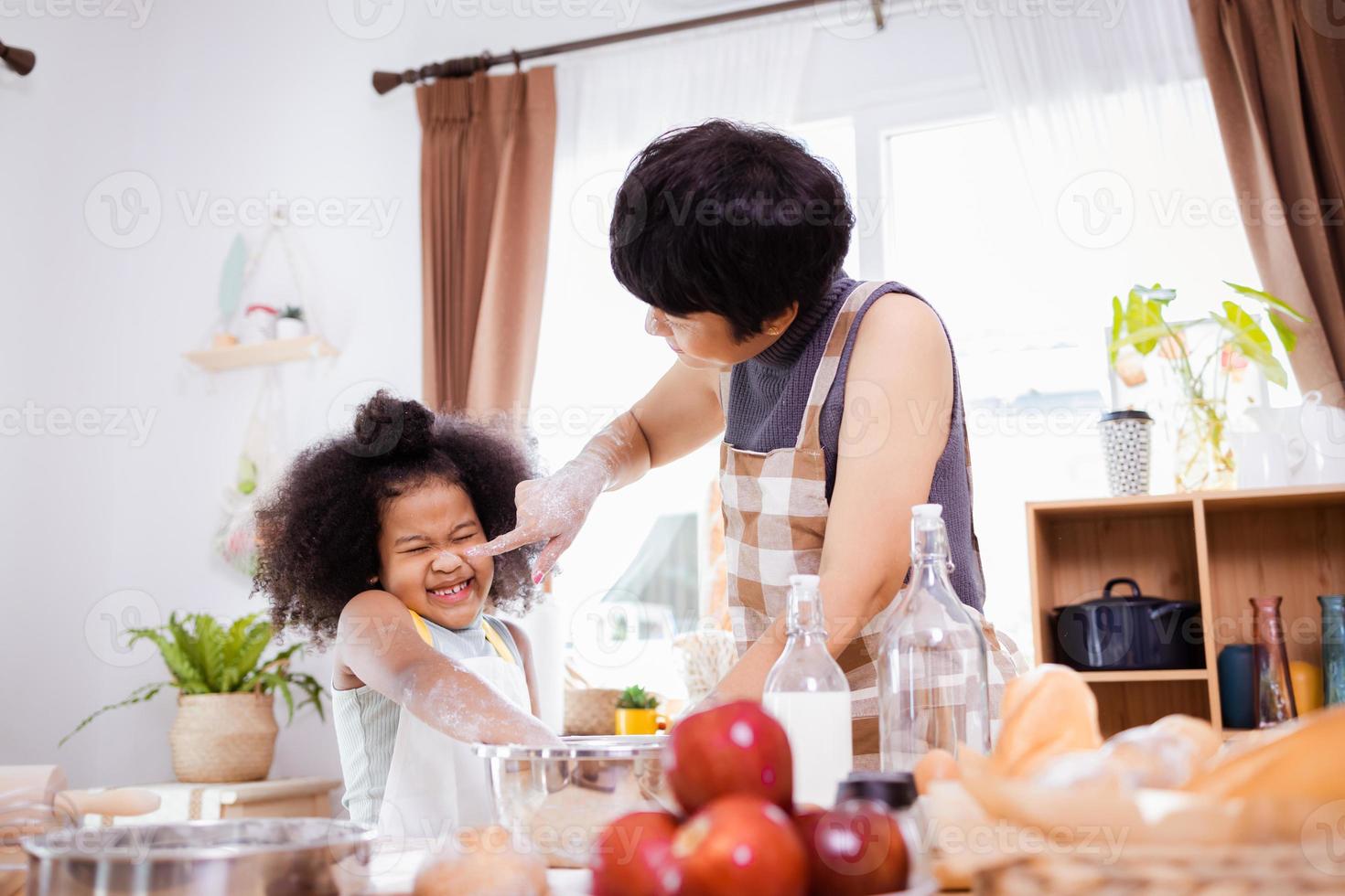 Happy African American family enjoy together while prepare the flour for making cookies at home photo