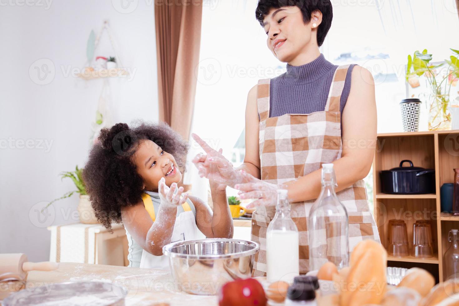 contento africano americano familia disfrutar juntos mientras preparar el harina para haciendo galletas a hogar foto