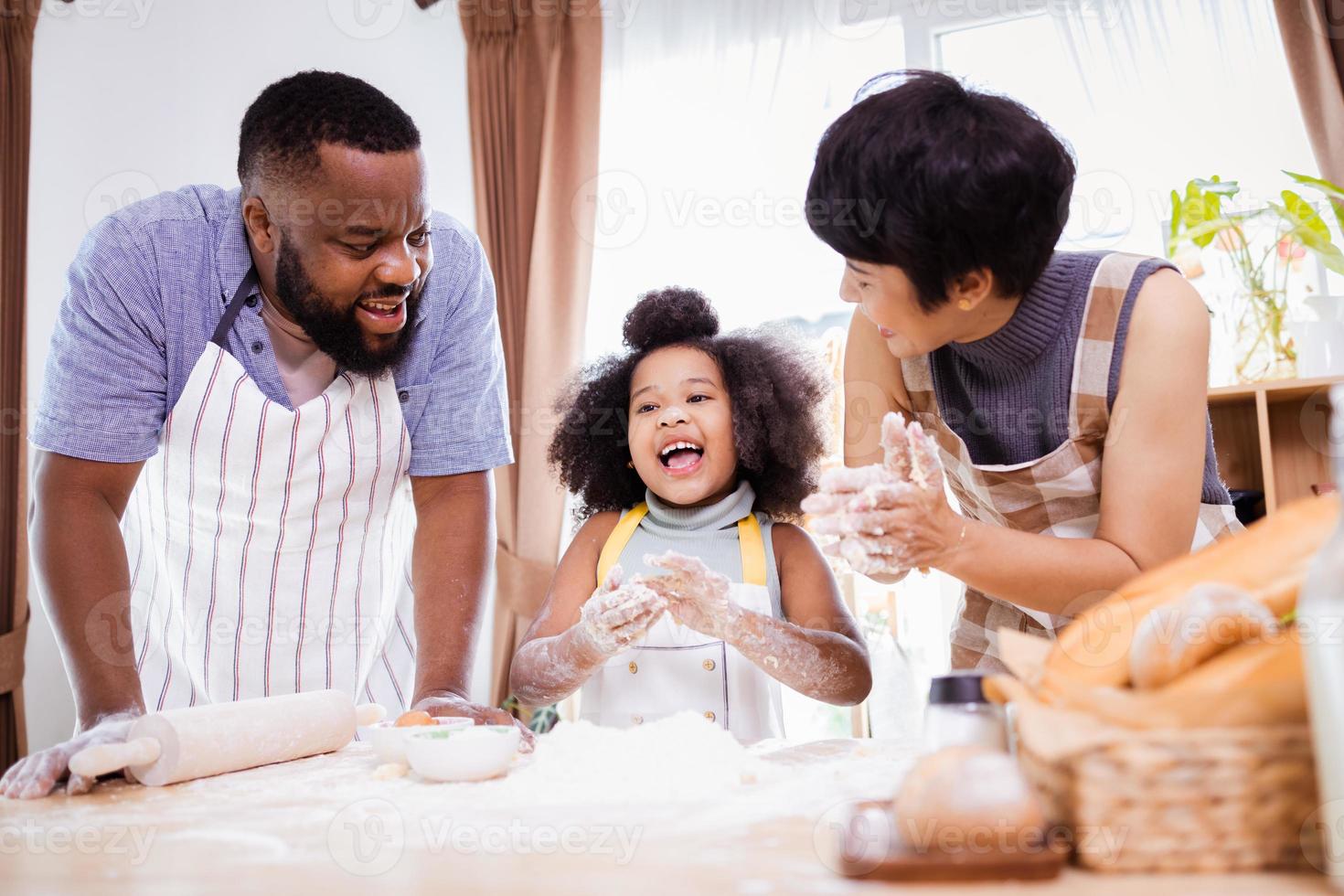 contento africano americano familia disfrutar juntos mientras preparar el harina para haciendo galletas a hogar foto