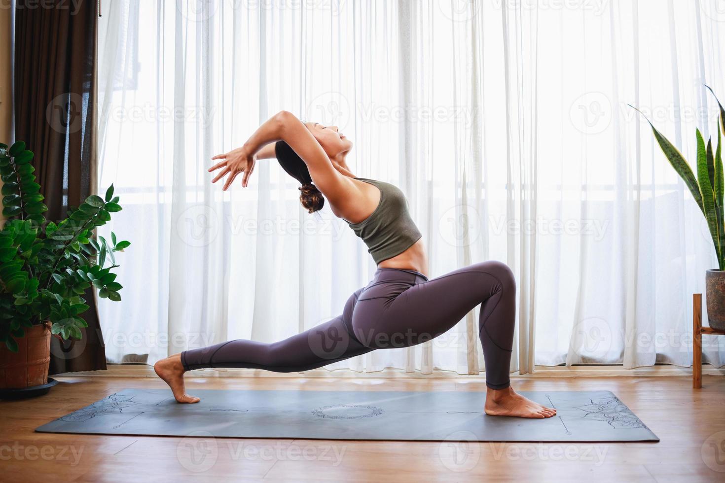 fortalecer tu mente y cuerpo con un asiático mujer hogar yoga práctica foto