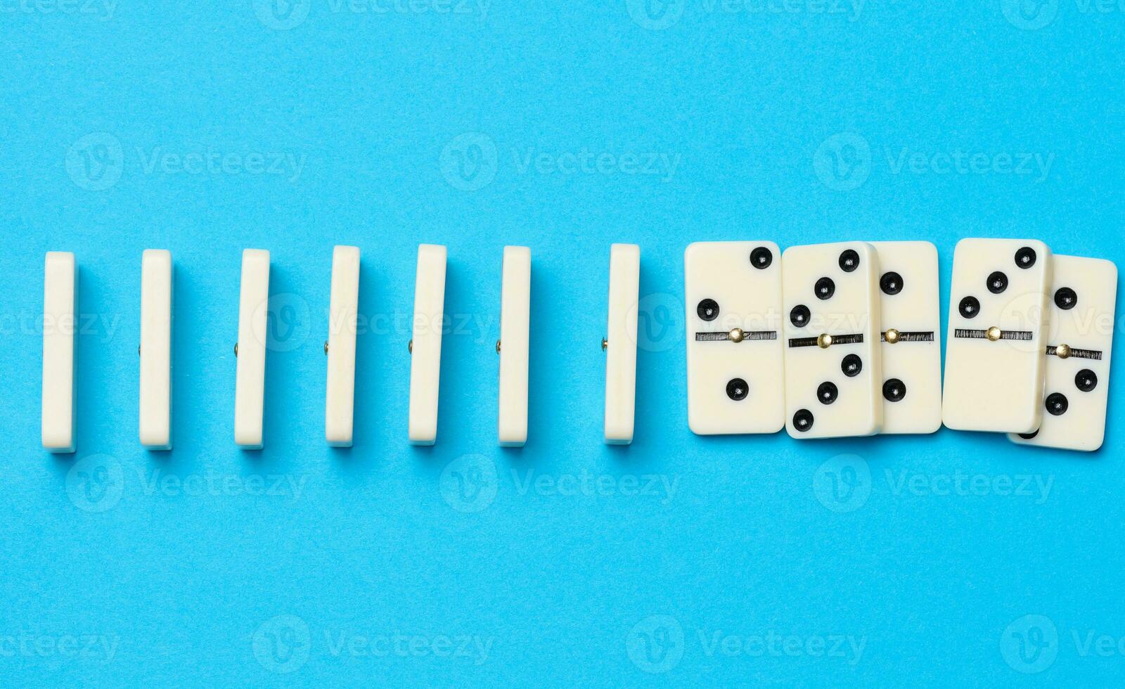 A stack of dominoes on a blue background, an intellectual game photo