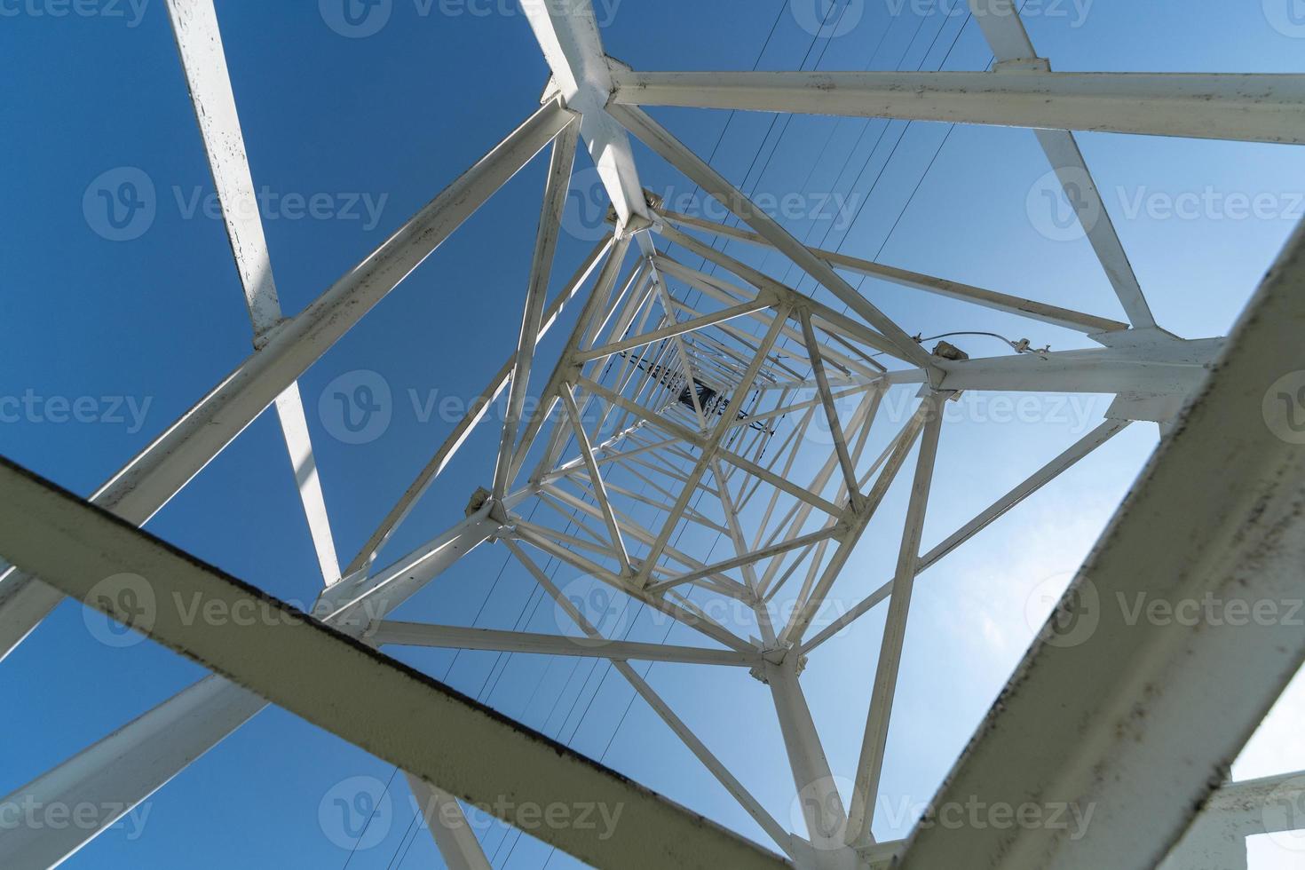 Transmission tower, view from below. Overhead pylon power line tower, distribution and transmit electrical energy across large distances. photo