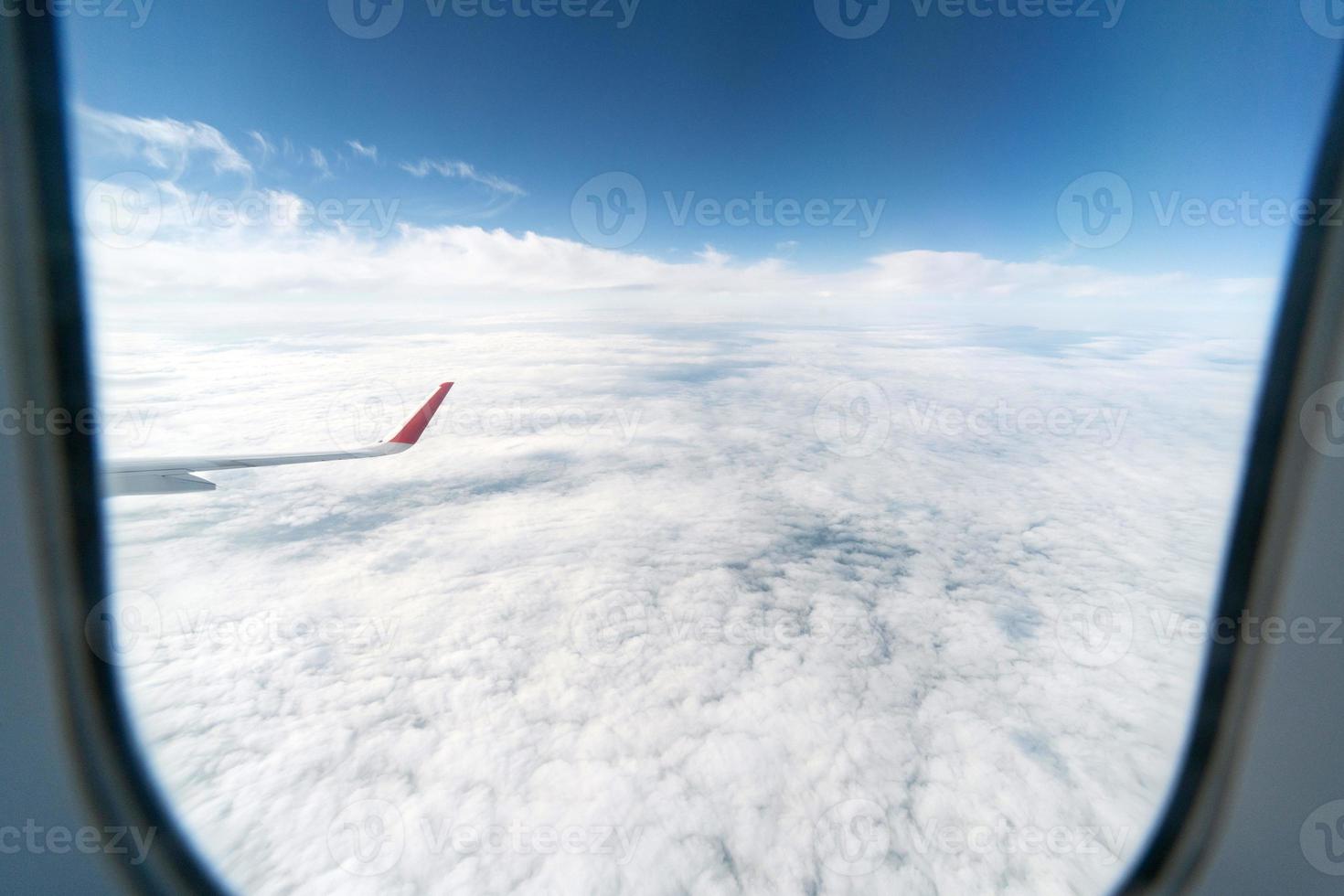 Airplane window view to cloudy sky. Beautiful landscape from aircraft cabin. Flying without incident and turbulence. photo