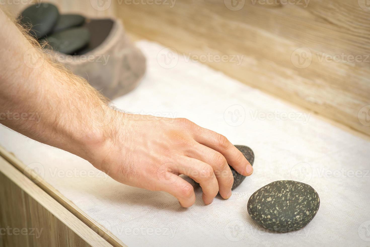 masajista es tomando masaje piedras foto