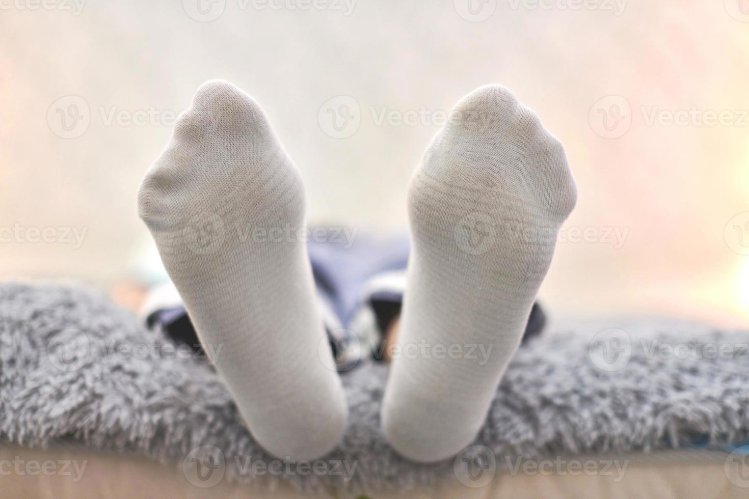 Woman resting on sofa in white striped socks, close up. photo