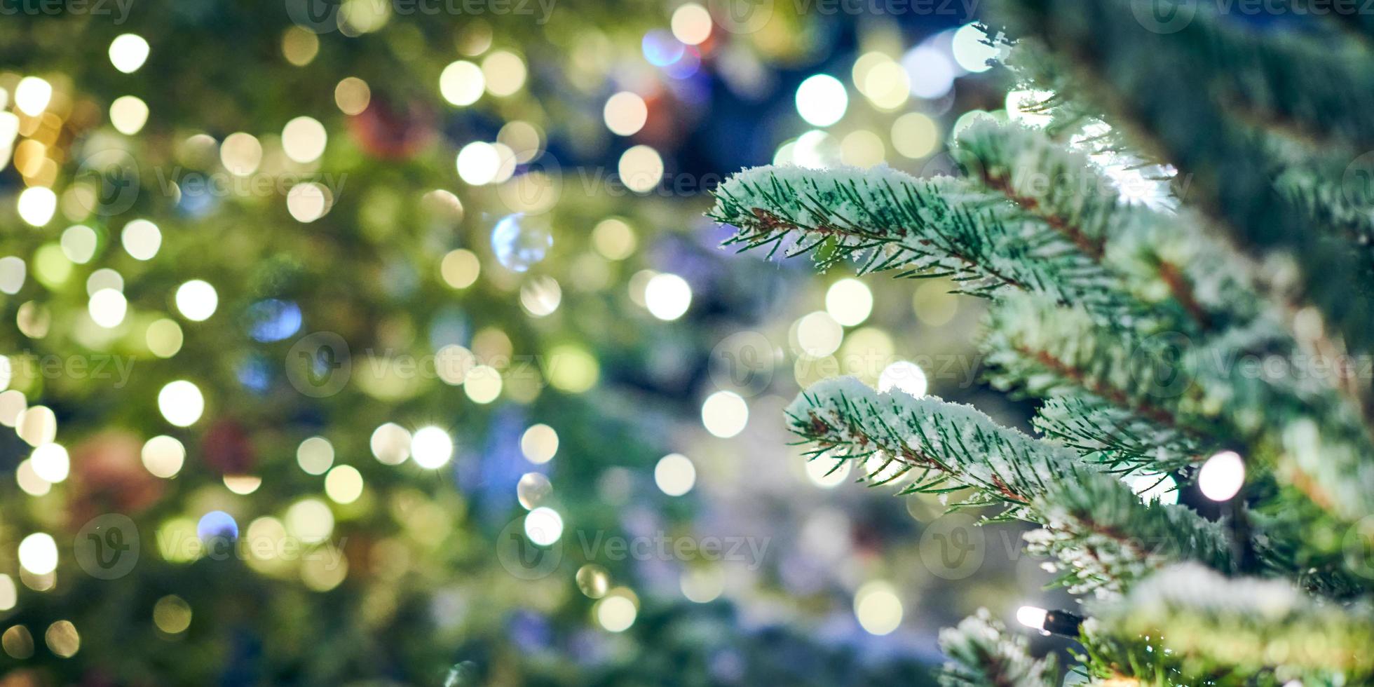 Christmas tree covered snow with yellow garlands lights and bokeh copy space with sparkled lights photo