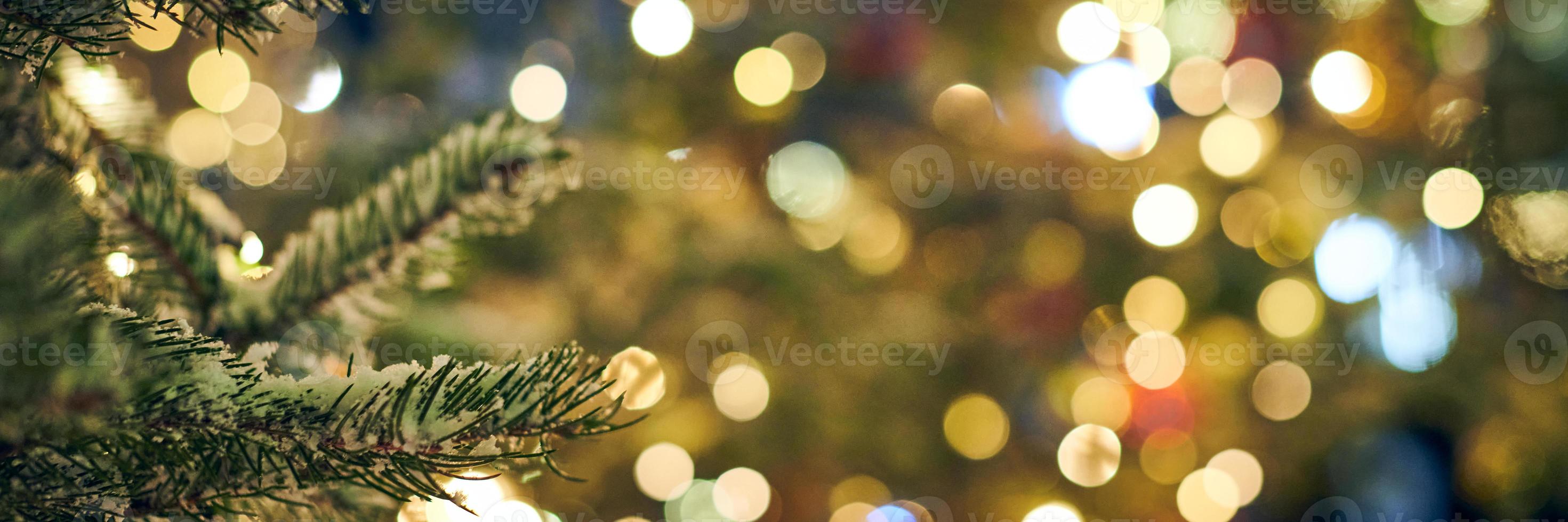Christmas tree covered snow with yellow garlands lights and bokeh copy space with sparkled lights photo