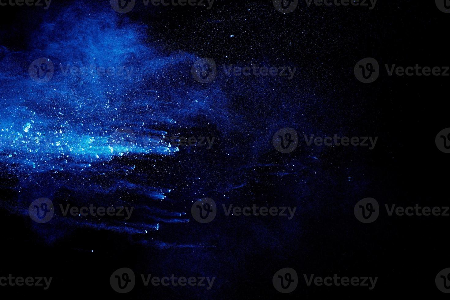 Blue  color powder explosion cloud on black background. Closeup of Blue  dust particles splash. photo