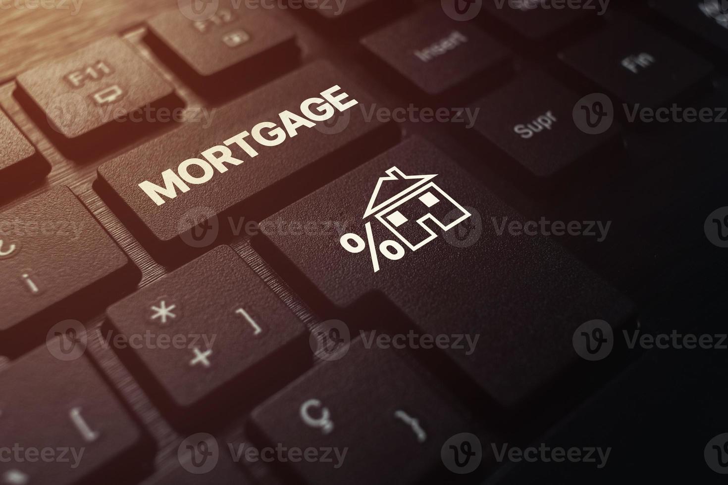 Black keyboard with mortgage word on button. Home mortgage loan concept. Make a contract for hire purchase and sale of a house. photo