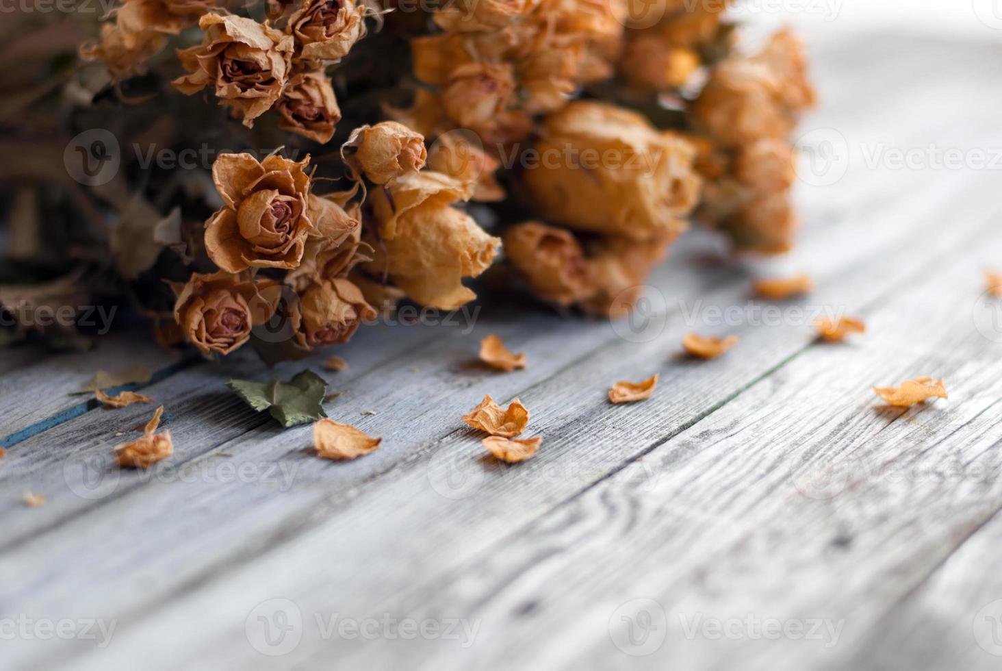 marchito manojo de flores, seco rosas en de madera mesa foto