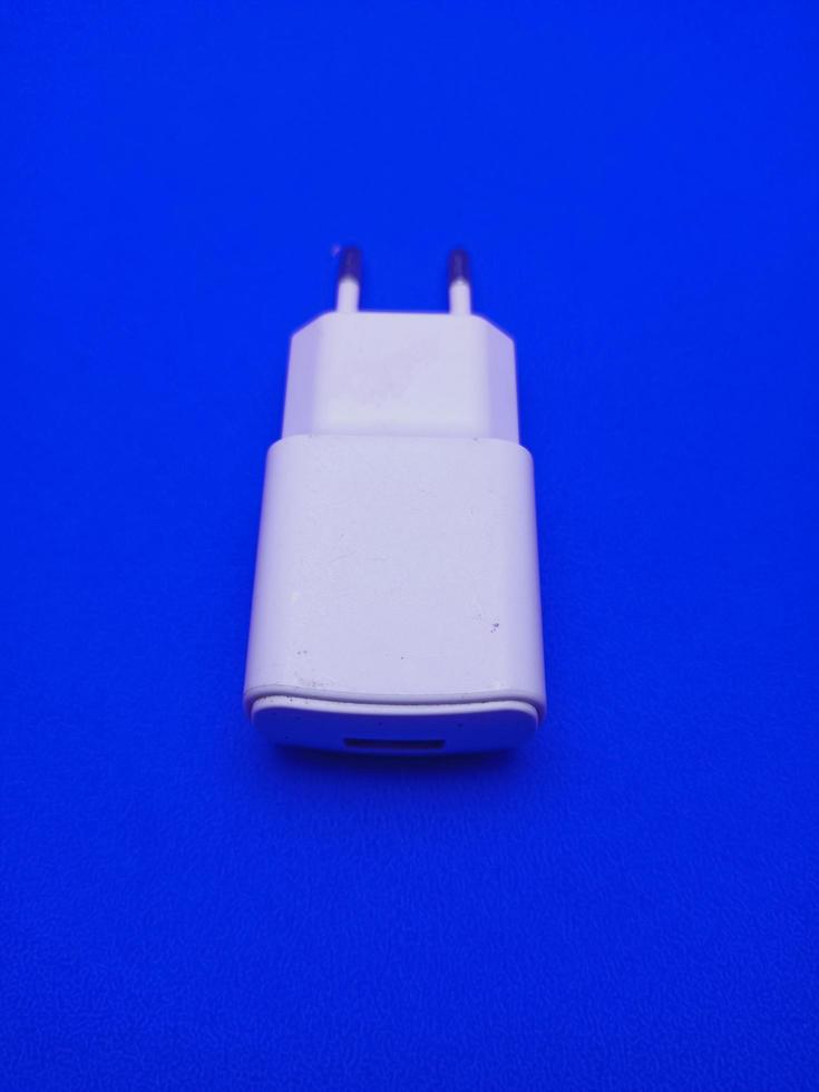 blanco teléfono inteligente cargador aislado con azul antecedentes imagen foto