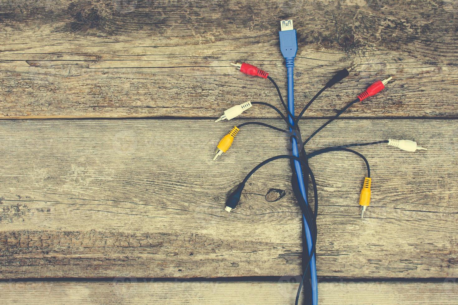 Connection plugs and wires on old wooden background. Toned image photo