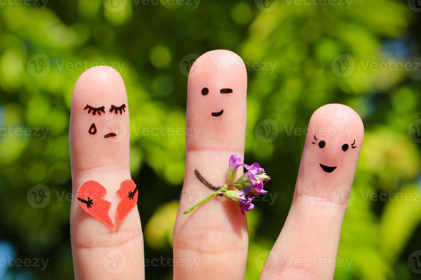 Finger art of people. Man flirts with woman. Other girl is holding broken heart. Concept of cheating in relationship. photo