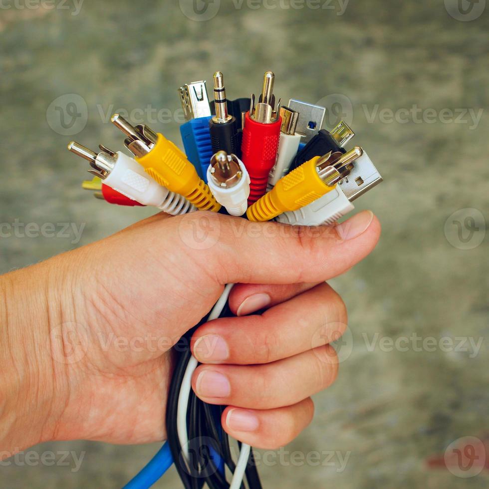 Hand holds colorful universal recharger heads. Toned image. photo