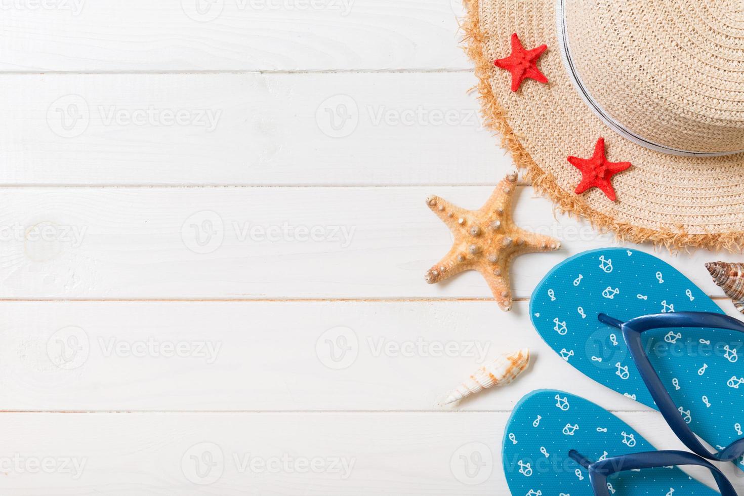 Straw hat, blue flip flops and starfish On a white wooden background. top view summer holiday concept with copy space photo