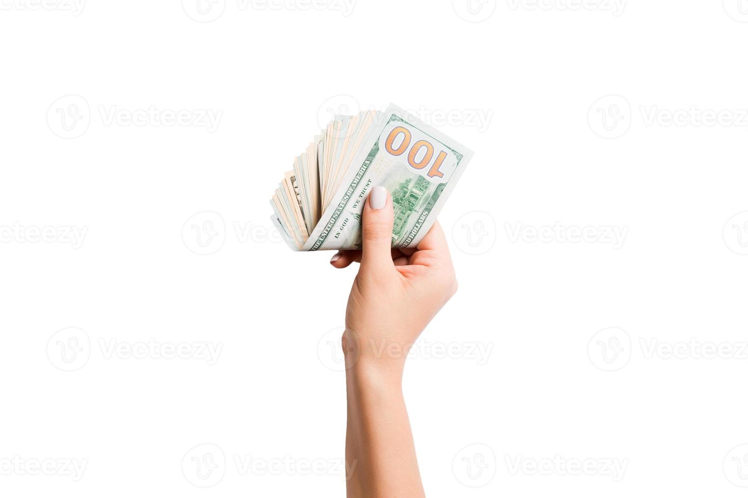 Female hand giving money on white isolated background. Top view of dollar banknotes. Bribe concept. Debt and loan concept photo