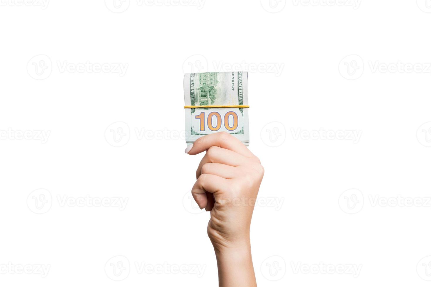 Isolated image of female hand holding a bundle of dollars on white background. Payment concept photo
