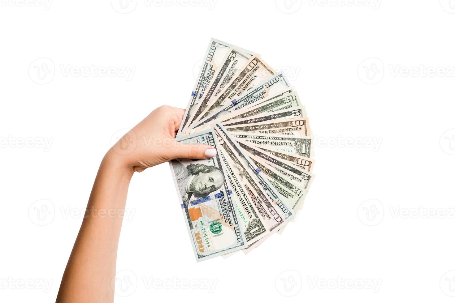 Female hand holding a fan of dollar banknotes on isolated background. Succes and investment concept photo