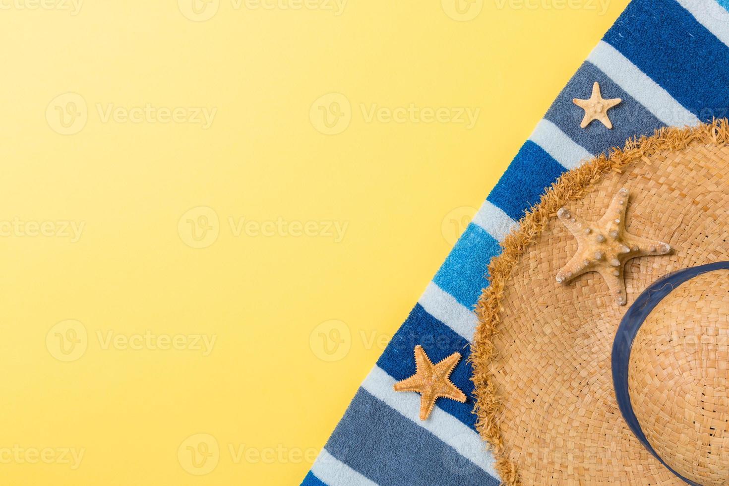 Straw hat, Blue towel and starfish On a yellow background. top view summer holiday concept with copy space photo