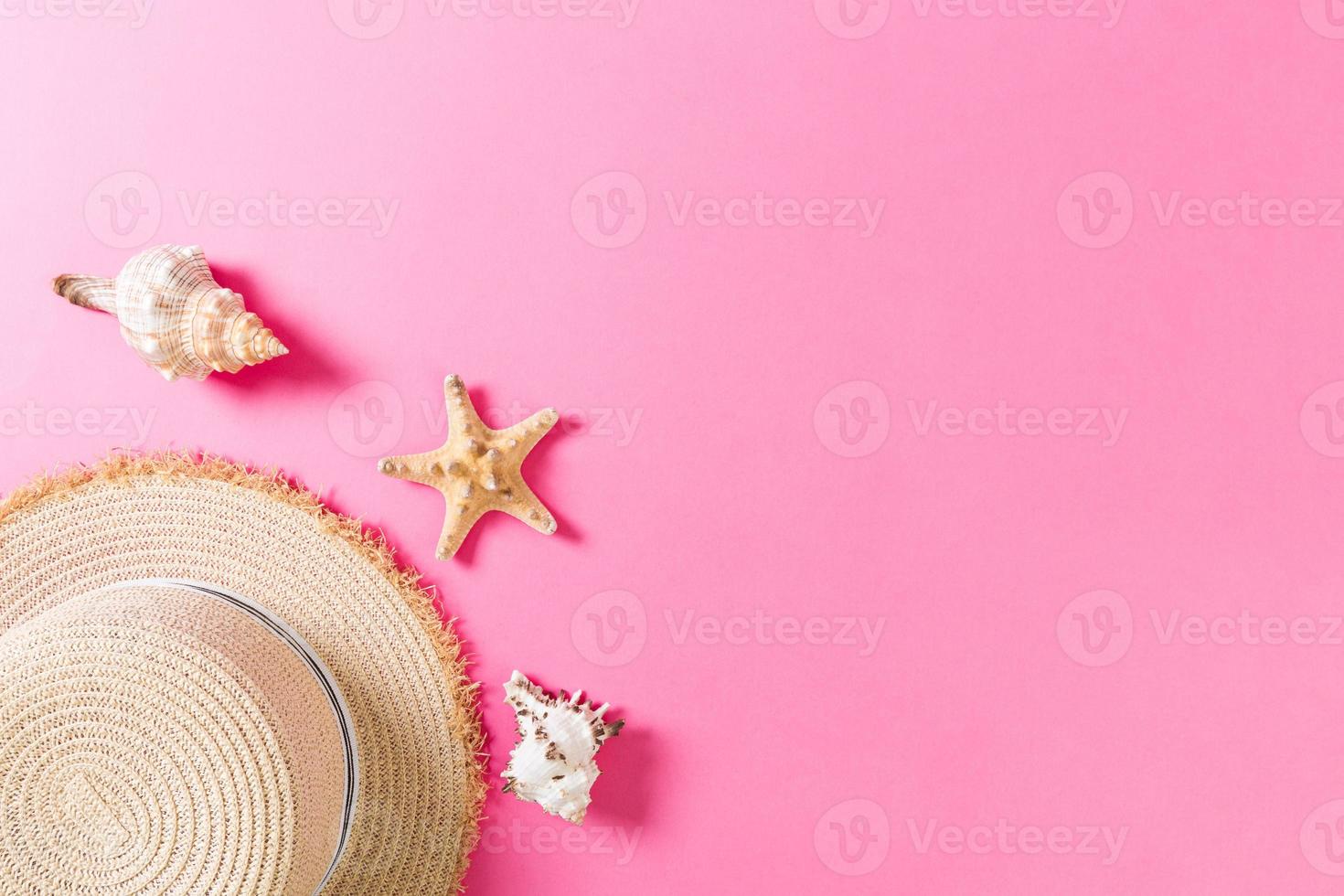 Beach hat with seashells on pink wooden table. summer background concept with copy space top view photo