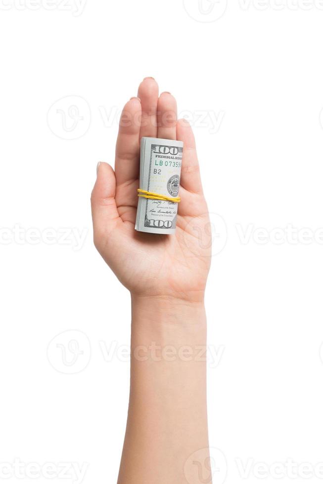 Top view of dollar bills rolled up in tubes in female palm on white isolated background. Retirement concept with copy space photo