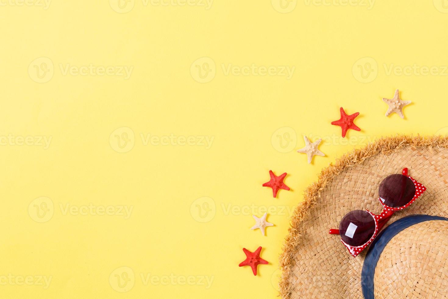 summer holiday beach background with accessories on yellow table, top view with copy space. vacation concept photo