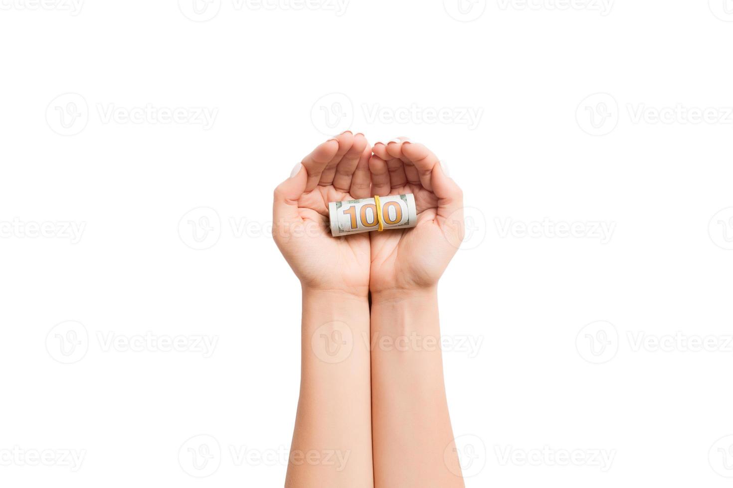 Rolled up dollar bills in female palms on white isolated background. Poverty and poor concept photo