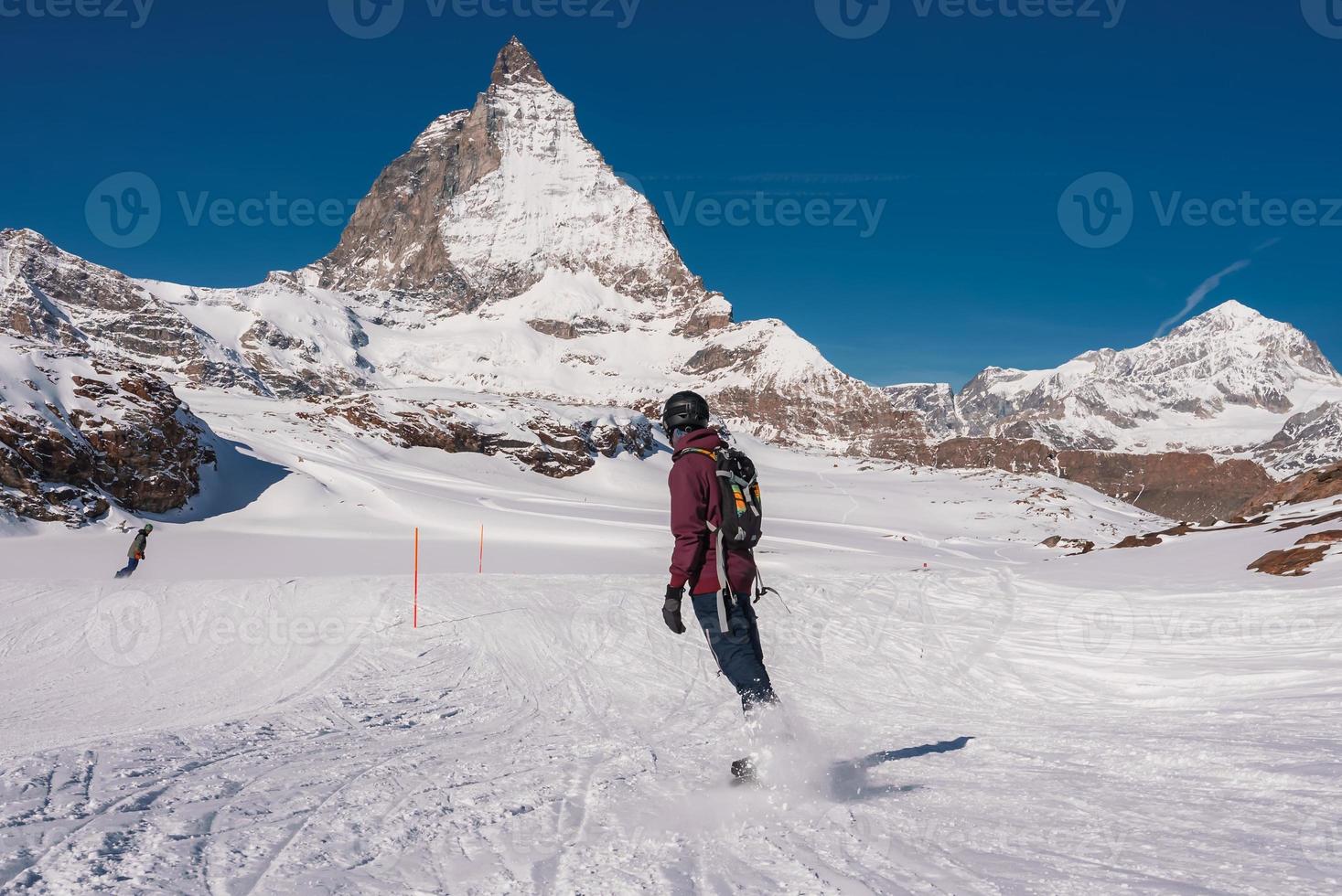 joven hombre Snowboarding en zermatt esquí recurso Derecha siguiente a el famoso materia cima. hermosa soleado día para Snowboarding. invierno Deportes concepto. foto