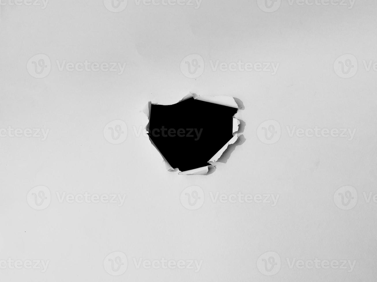 papel marco con el rasgado agujeros un negro agujero en el blanco papel. para Copiar espacio antecedentes cubrir foto