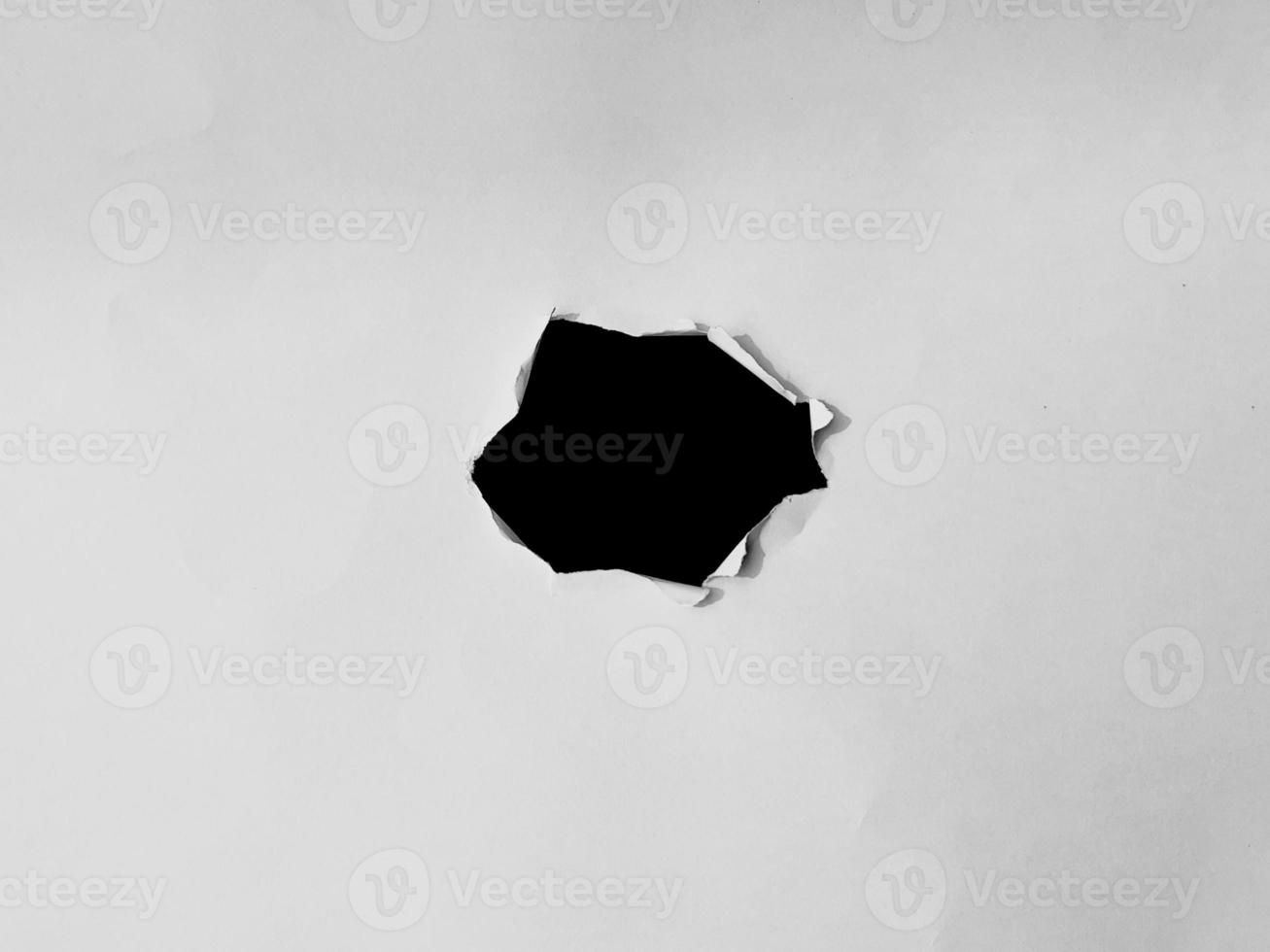 paper frame with the ripped holes. a black hole on the white paper. for copy space background overlay photo