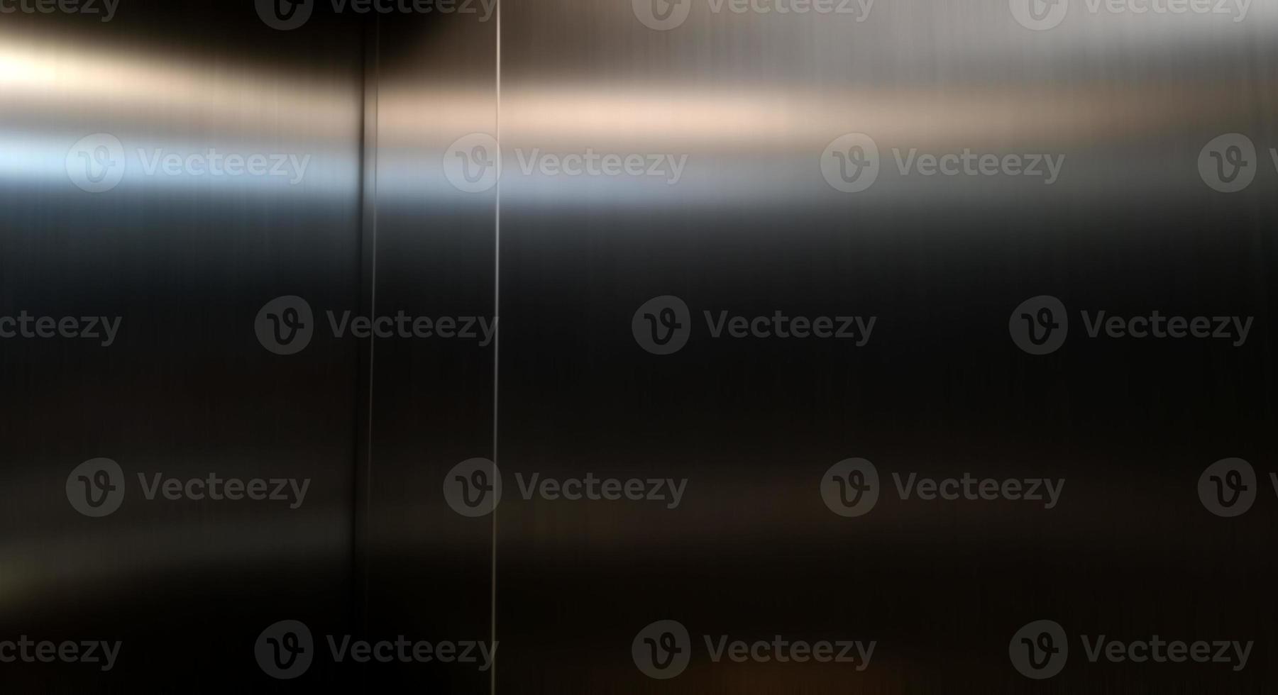 Stainless steel large sheet  With light hitting the surface,Inside passenger elevator,Reflection of light on a shiny metal texture,stainless steel background,metal texture background. photo
