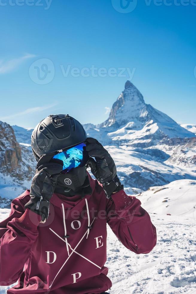 joven snowboarder gasto invierno Días festivos en zermatt, cerca el famoso materia cima. masculino posando en suizo Alpes para el Snowboarding estación. foto