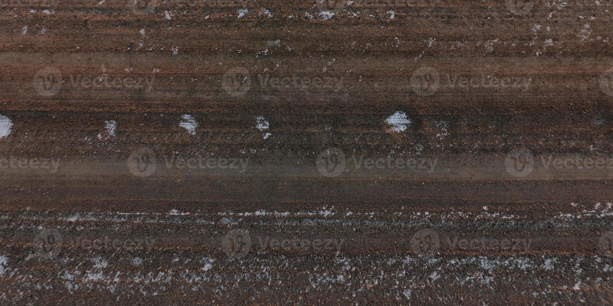 top view of surface of gravel road made of small stones and sand with traces of car tires photo