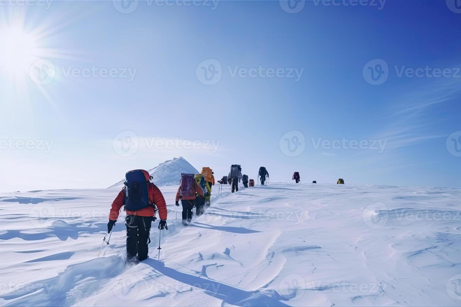 Group of mountain climbers climb the slope to the peak in sunny weather with sledges and tents equipment for overnight stays photo