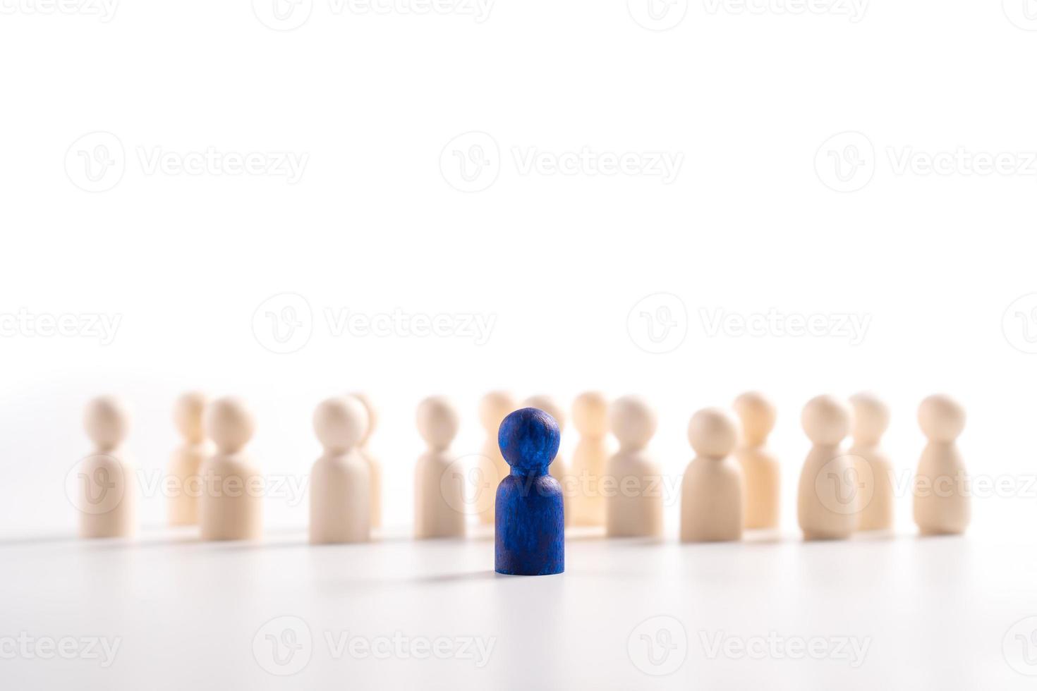 Wooden figure standing in front of the team to show influence and empowerment. Concept of business leadership for leader team, successful competition winner and Leader with influence photo