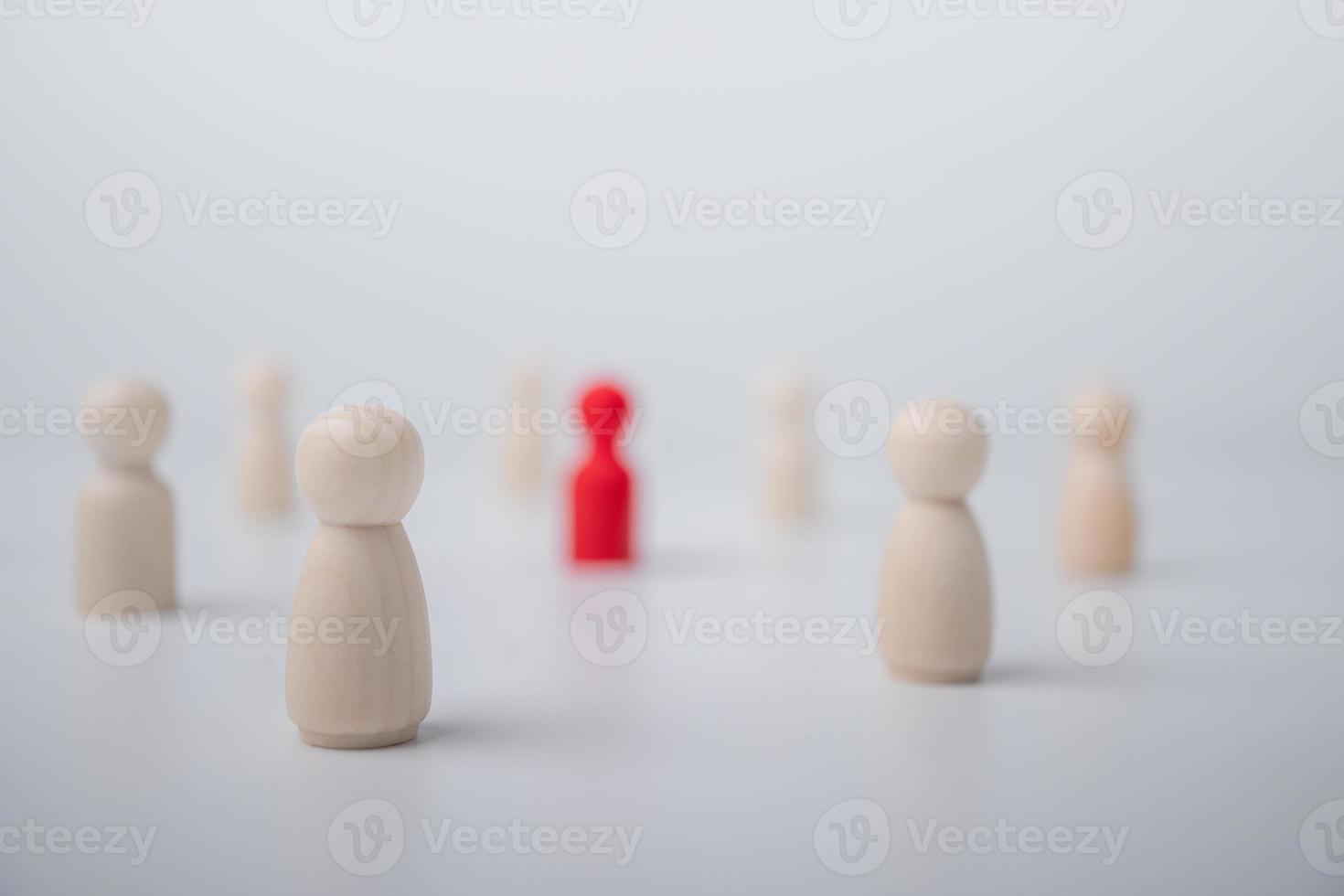 A wooden figure standing with a team to influence and empowerment. Concept of leadership, successful competition winner and Leader with influence and Social distancing for a new normal lifestyle photo