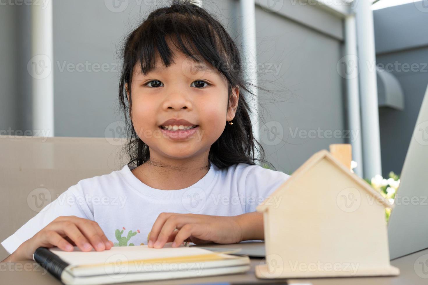 Asian girl student using the laptop for online learning class and doing homework at home, Education and distance learning for children Homeschooling concept photo
