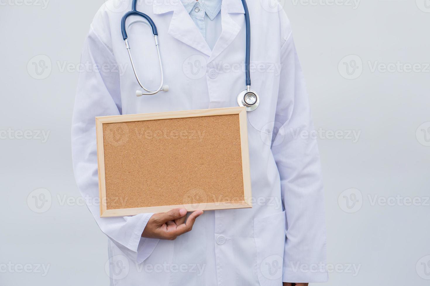 profession doctor in white coat over white isolated background with white blank board. Concept of healthcare, science and medicine concept photo