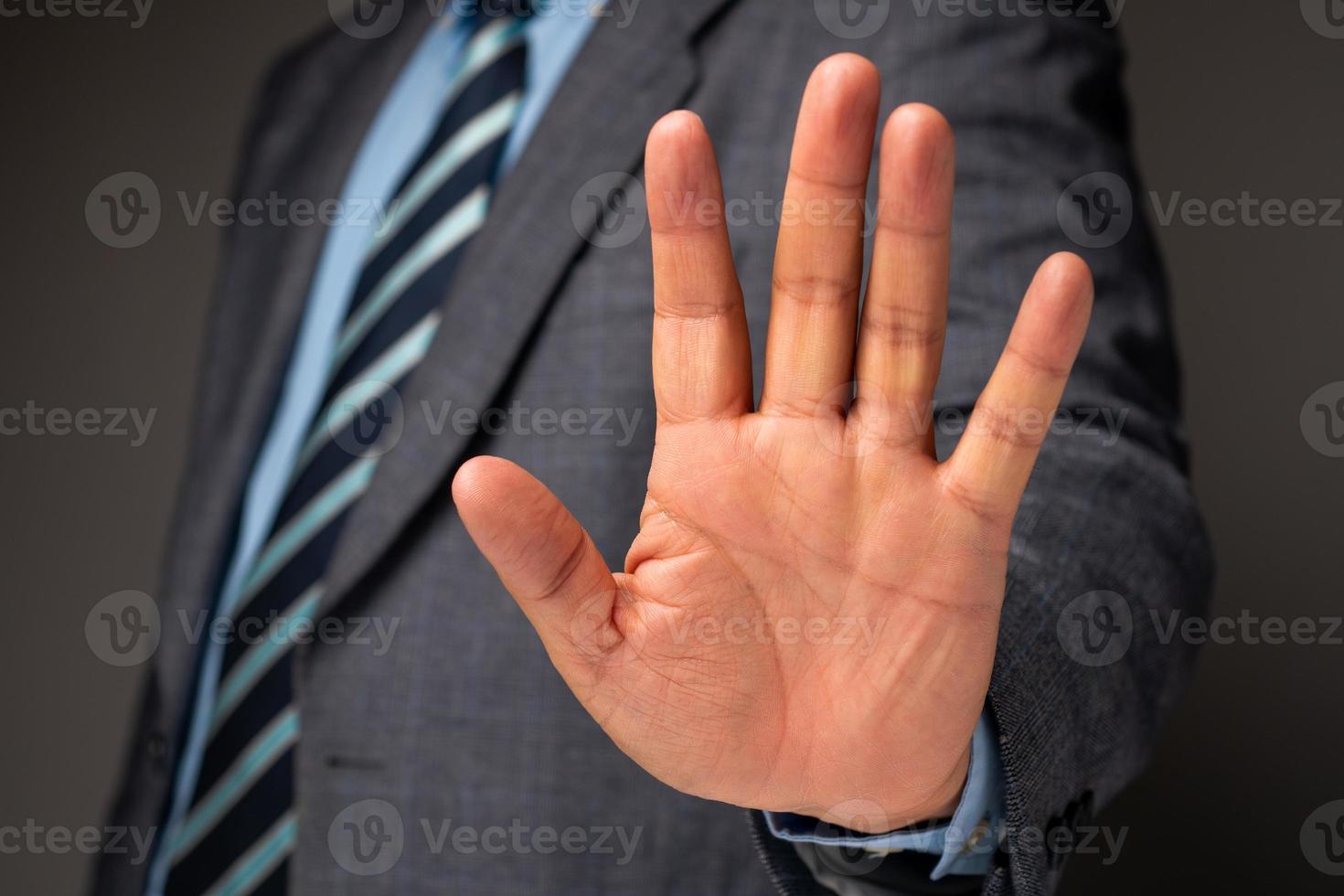 Businessman show hand sign for stop and holding, Concept of professional warning for stop new investment in world crisis photo