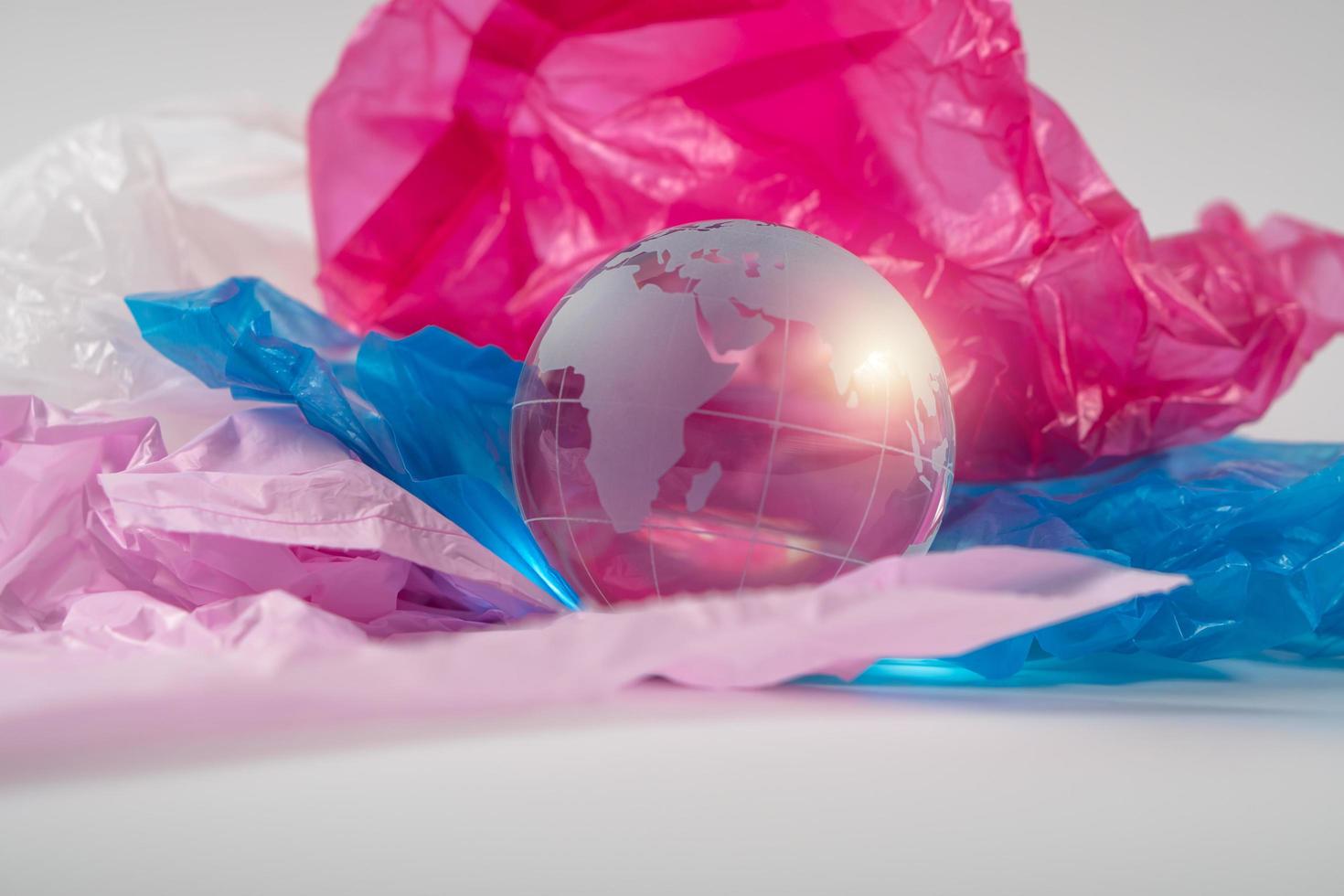 The crystal globe on plastic bag. Plastic waste overflows the world. Global Warming and Climate Change concept. photo