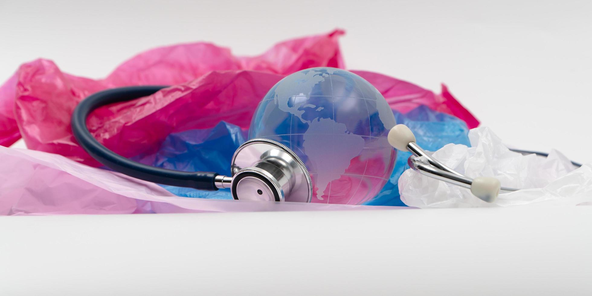 Crystal globe and Stethoscope on plastic bag. Plastic waste overflows the world, The world is sick, Global Warming and Climate Change concept. photo