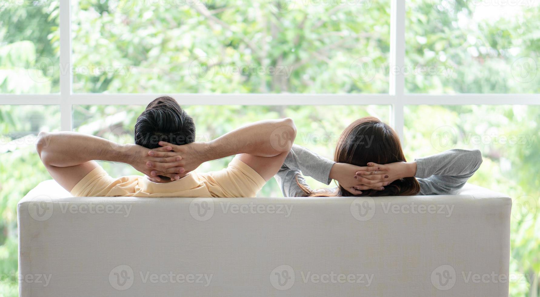 Happy couple sitting on the sofa and being a man embracing his girlfriend with love in the living room and relax. Concept of romantic on valentine day. Proposal and marriage photo