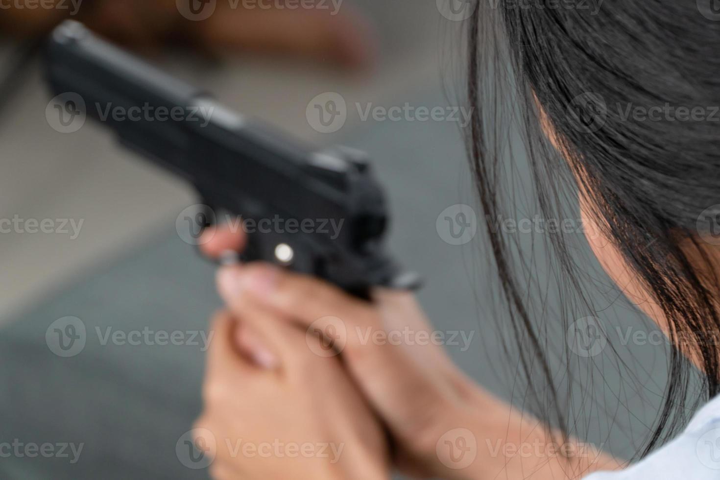 Depressed middle-aged women holding a gun in living room due to stress in life and unable to find a solution and no advisor. Concepts of social issues, stress, and relationships in the family. photo