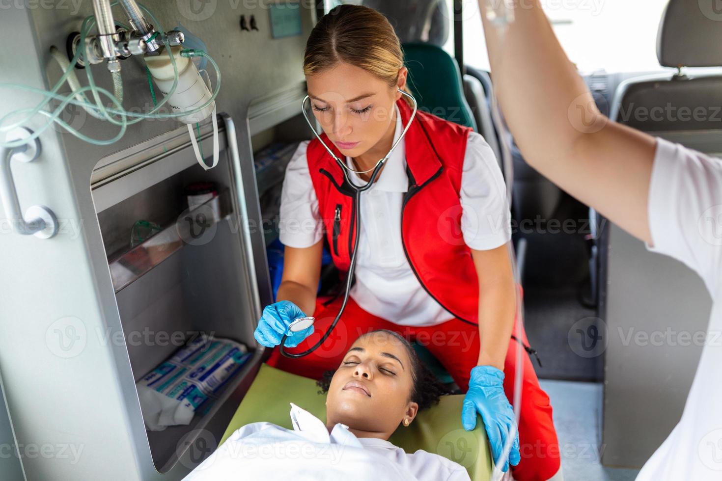 Young doctor with stetoscope listening patient heart and lungs. photo